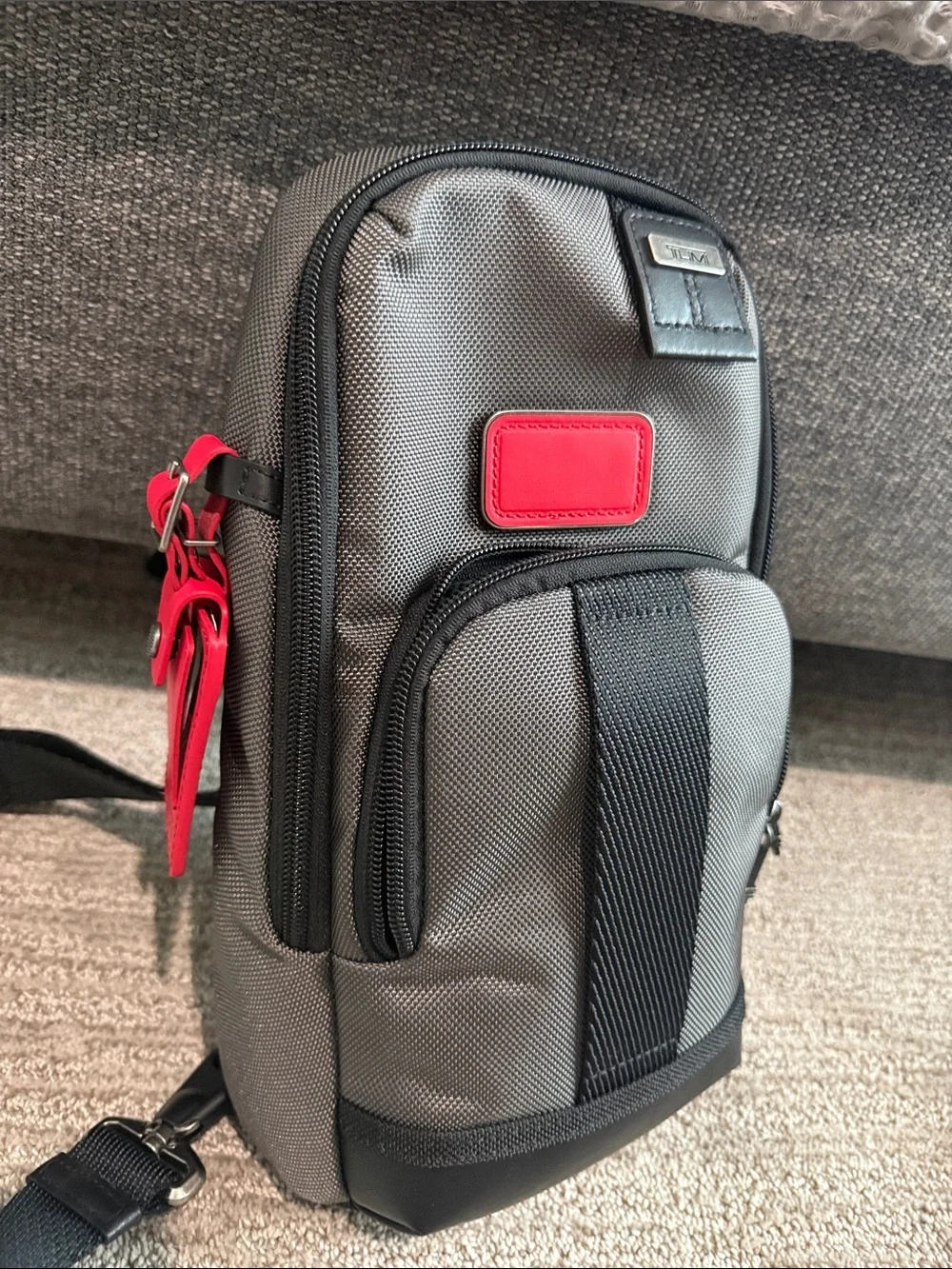 Tumi Gray Sling Bag with Red Accent- NEVER USED OR WORN. Tags removed, A gift